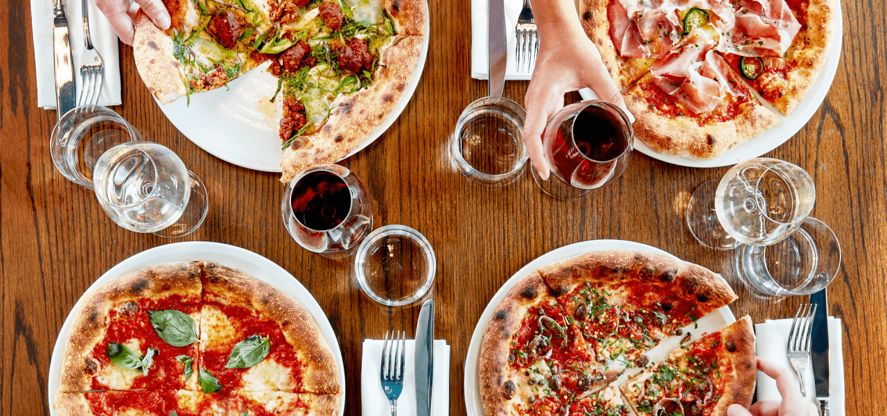 Table with pizza and wine at Pizzeria Mozza at Treehouse London